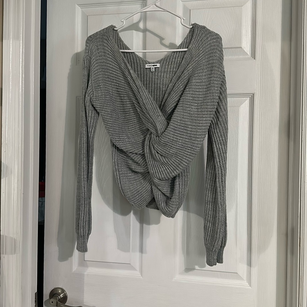 Cropped sweater with knot design in front.